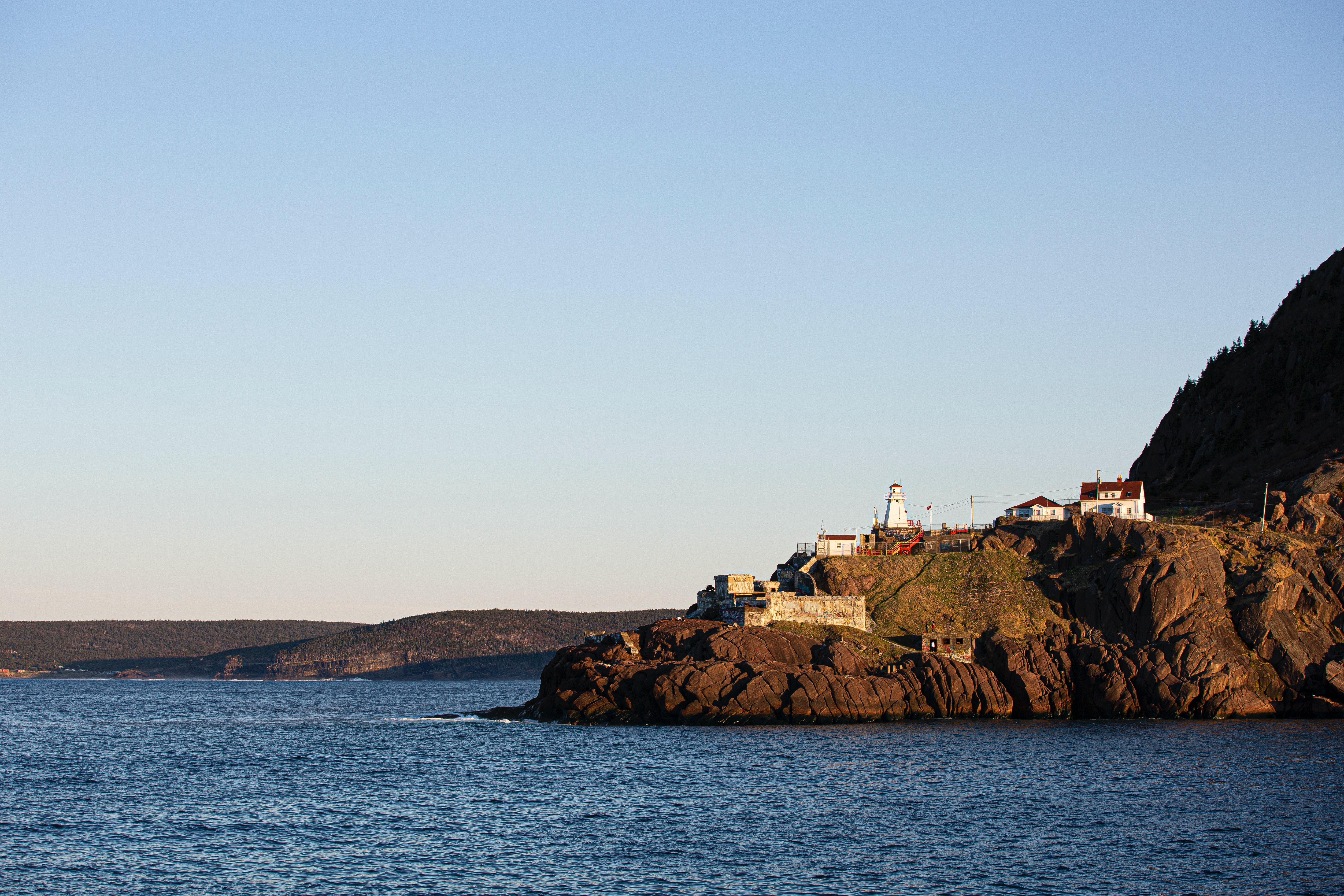 Costal view of a light house and other buildings on a headland